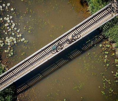 Zwei Radfahrer fahren über eine Brücke 