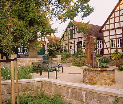 Blick auf den Ort von Hilter mit Brunnen und Sitzbank