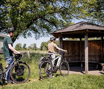 Zwei Radfahrer halten an einem Rastplatz 