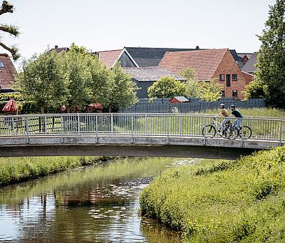 Zwei Radfahrer fahren über eine Brücke in Sassenberg 